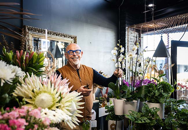 Murray Howell in his Te Puke Florist shop surrounded by orchids and proteas